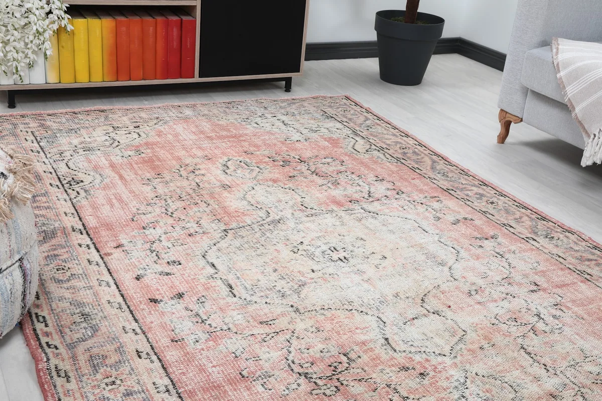 Close-up of the rug's central medallion and surrounding rose field in a room setting