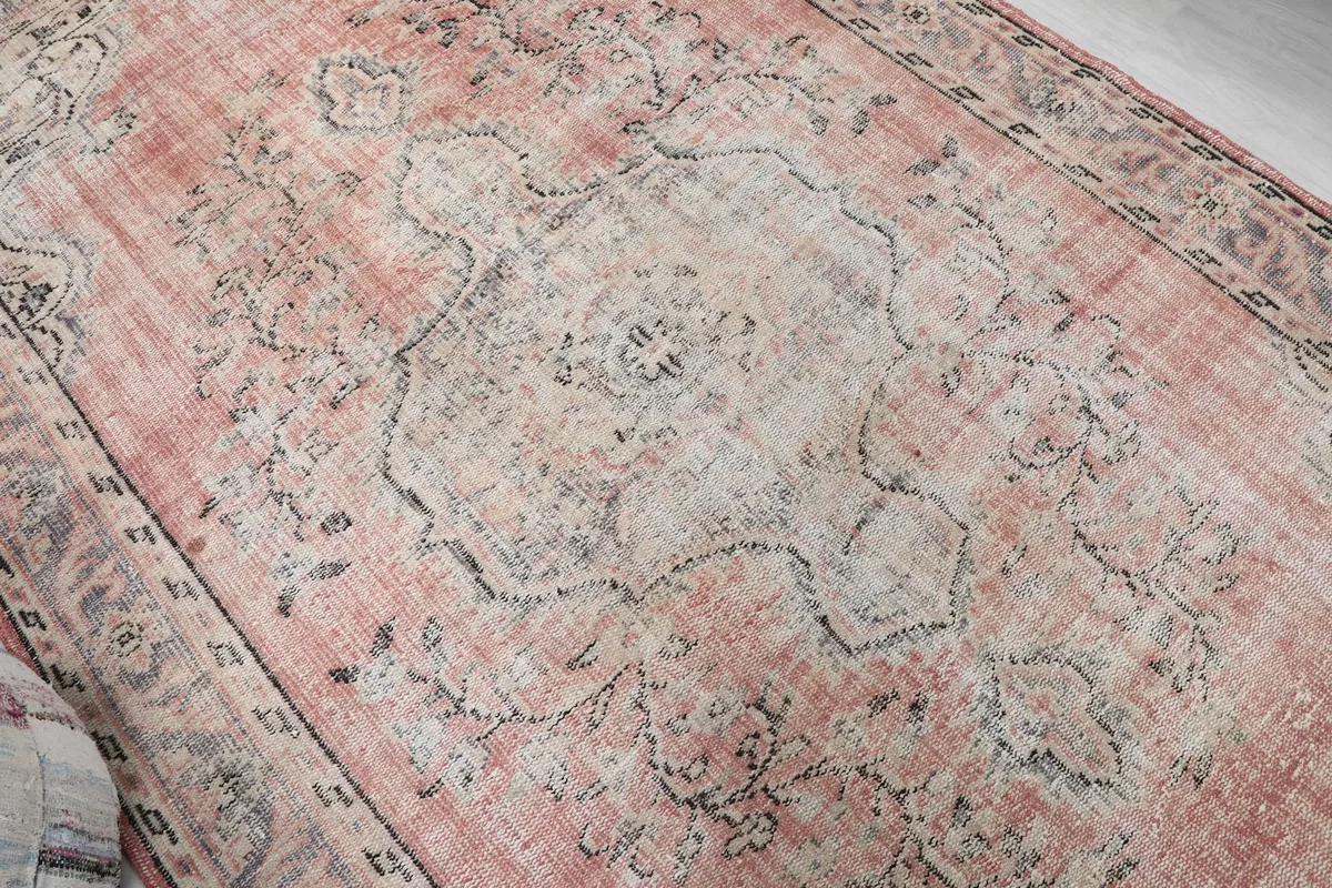 Overhead close-up of the central medallion and faded rose field, highlighting the wool texture