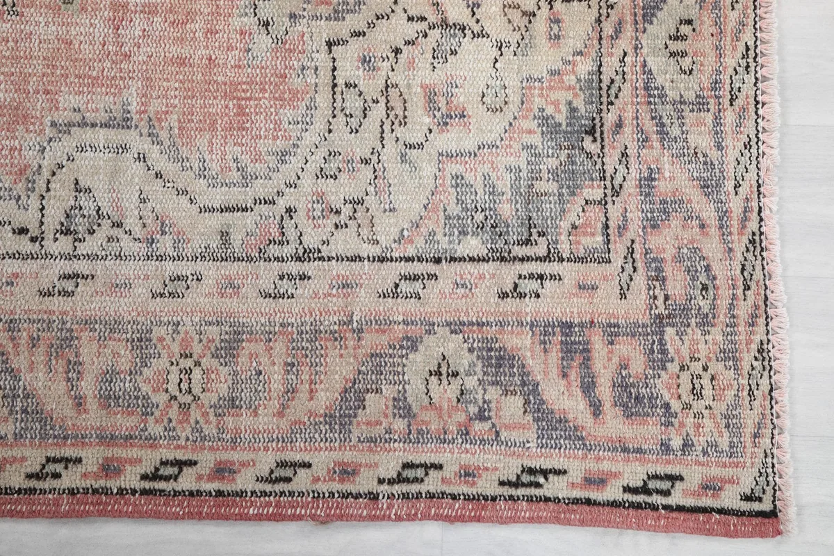 Detailed view of the rug's border pattern, showing gray and ivory geometric motifs