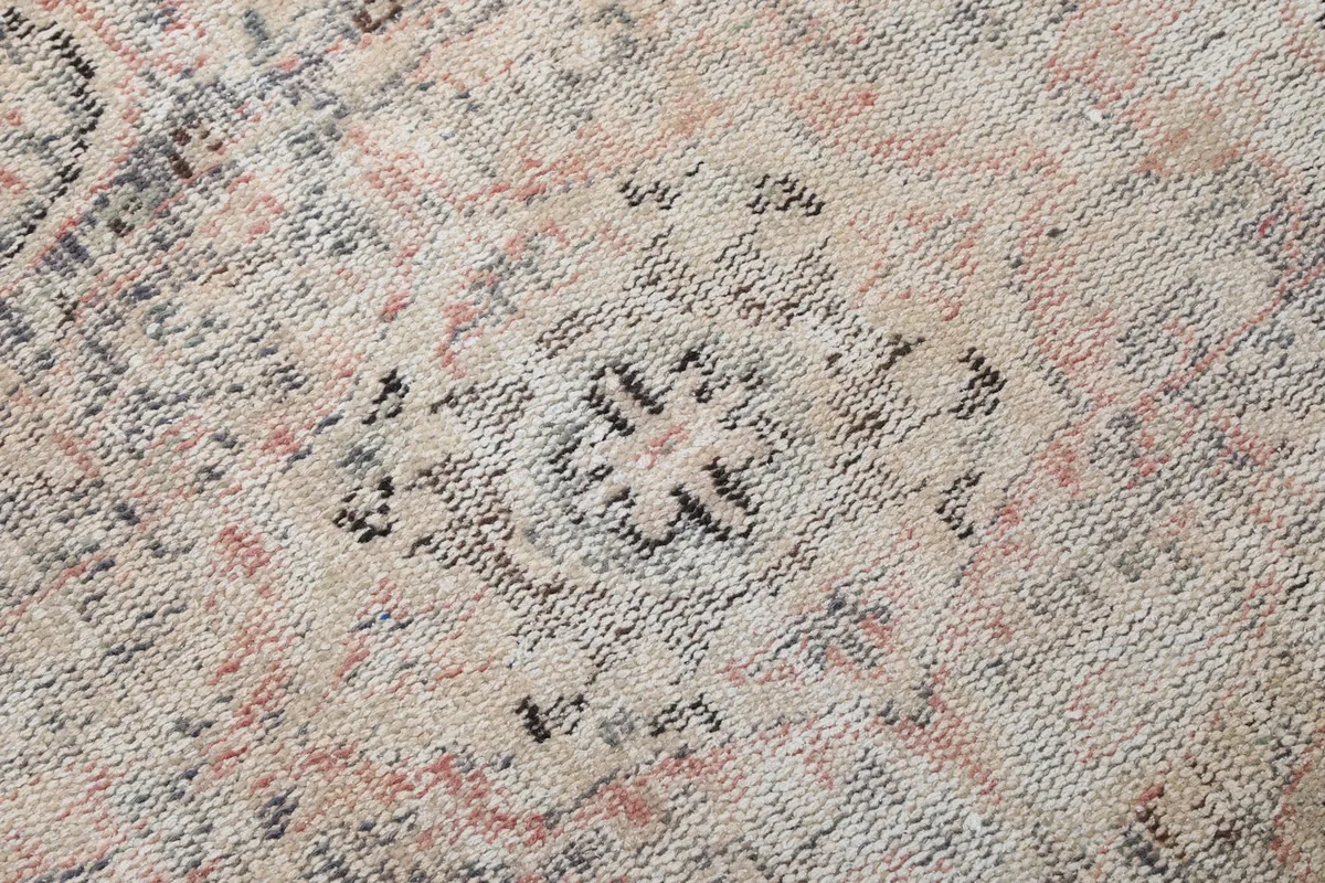 Extreme close-up of the low pile and intricate knotting of the rug, showing slight wear