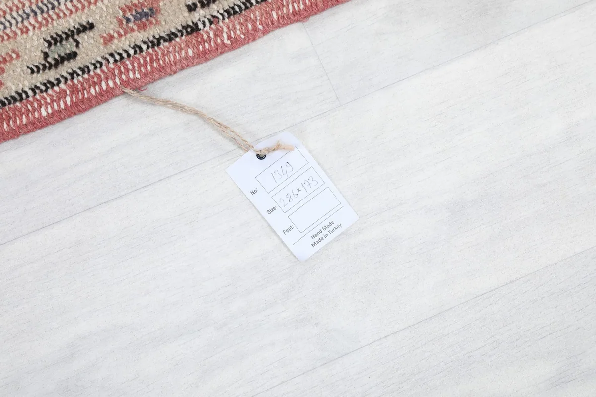 Close-up of the product tag attached to the rug, indicating its hand-knotted origin