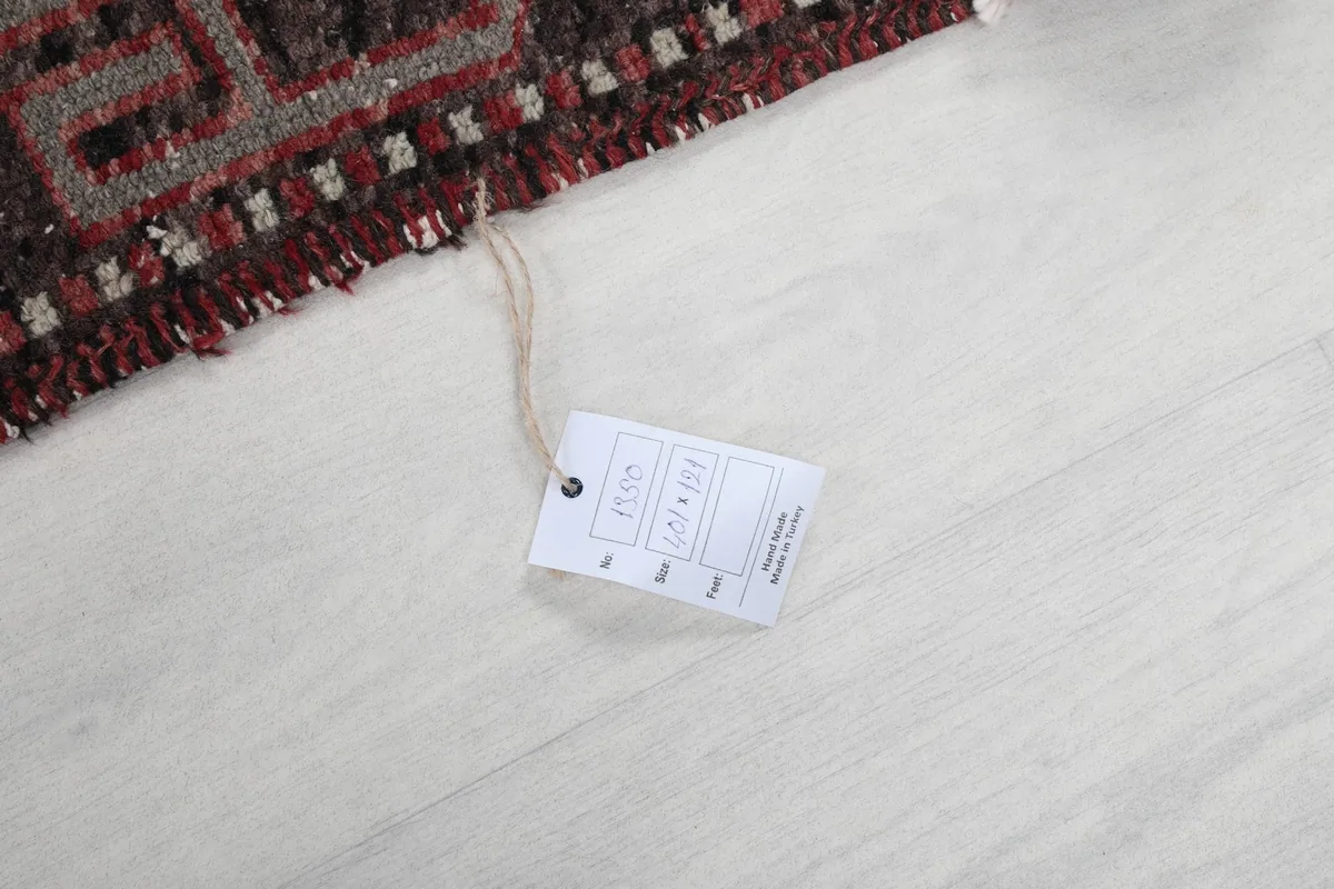 Close-up of the rug's tag with size information, resting on the floor next to the rug.