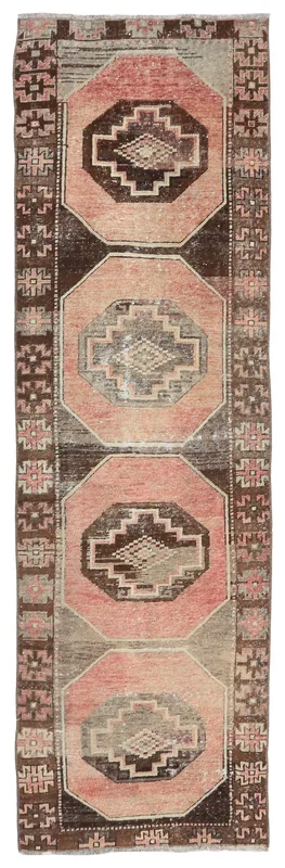 Full overhead view of the rose and brown geometric Anatolian runner rug on a white background