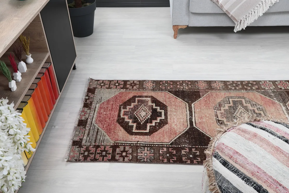 Wide angle view of the runner rug in the room, showing its placement relative to a sofa and ottoman