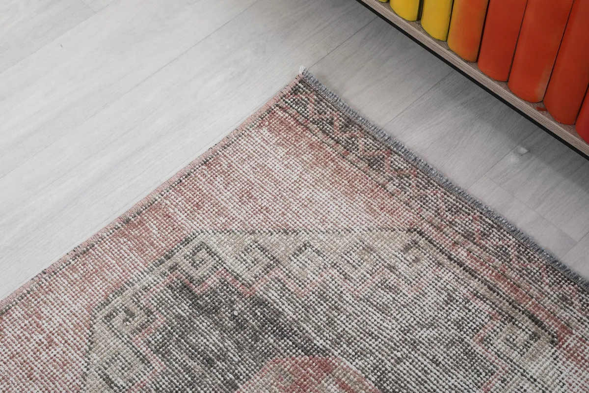 Corner detail of the runner rug, showing the geometric border and color variations.