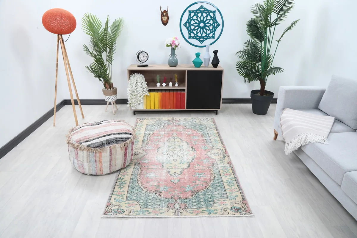 Vintage Anatolian rug placed in a modern living room setting with a gray sofa and wooden cabinet