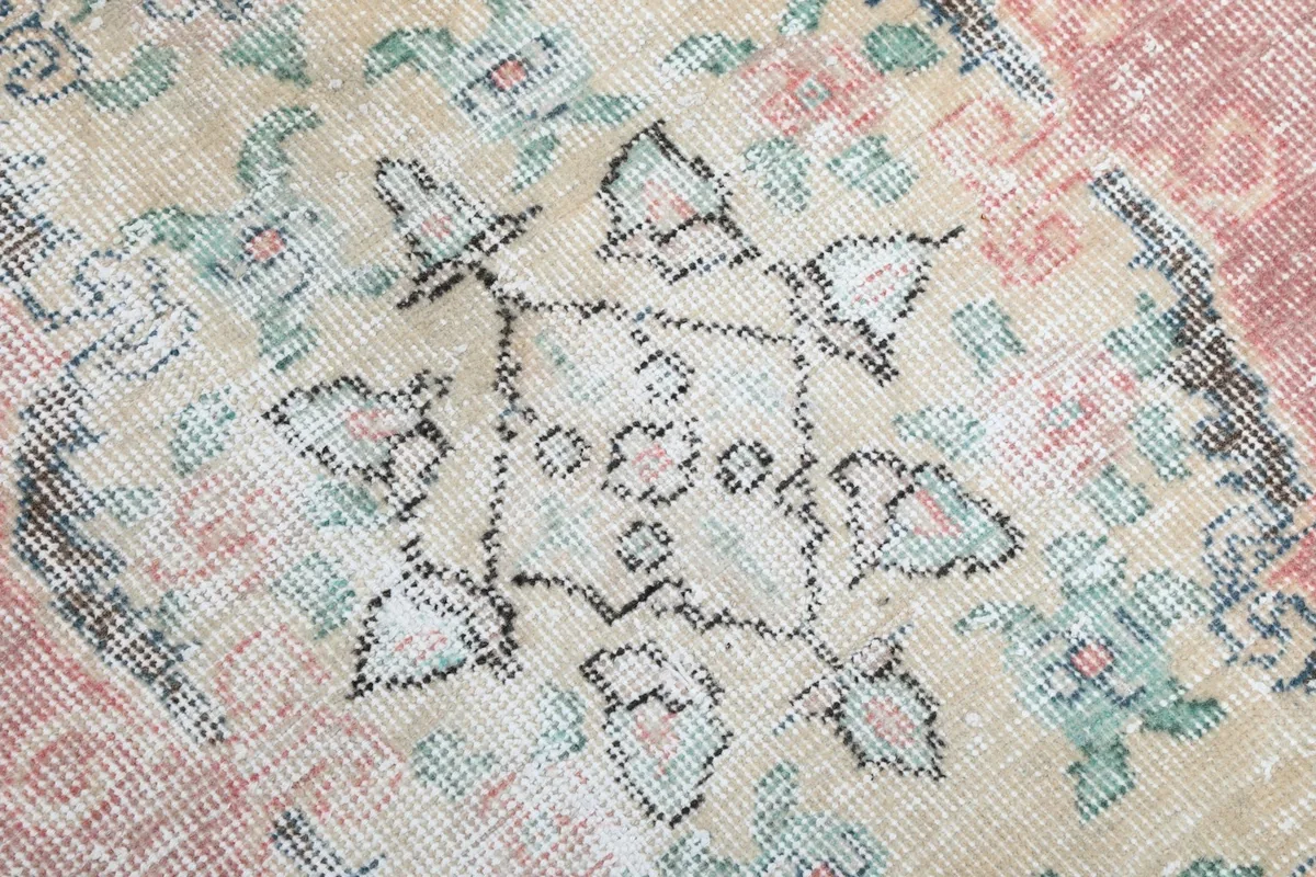 Close-up of the intricate floral and geometric details within the central medallion of the rug