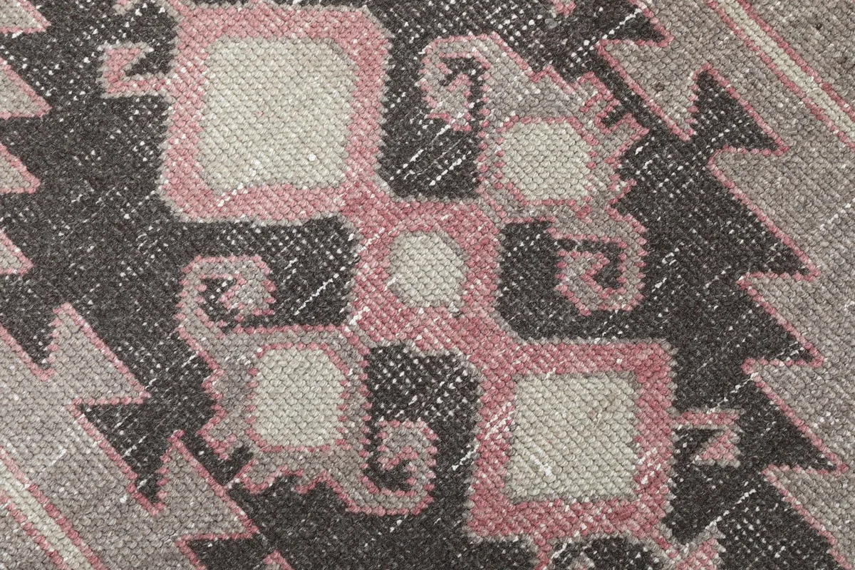 Extreme close-up of the hand-knotted wool pile and intricate tribal patterns