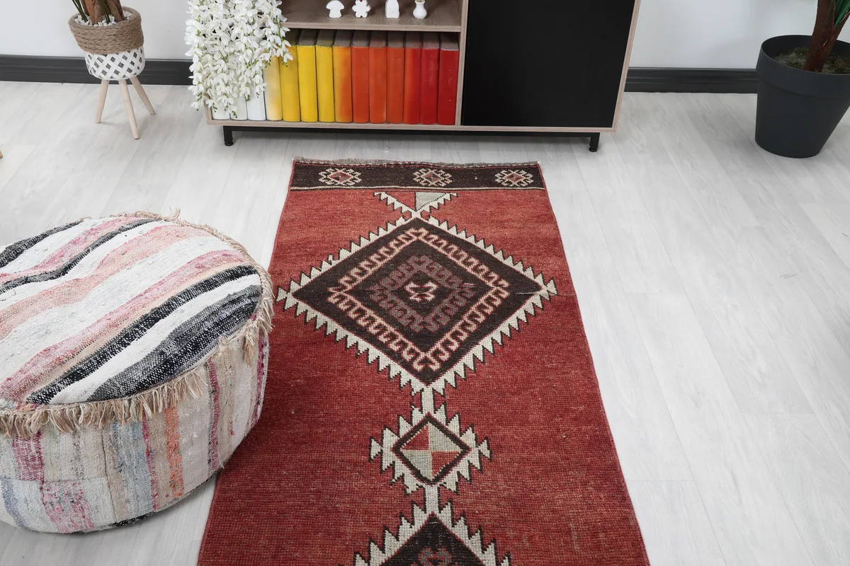 Rustic Red Tribal Diamond Runner in a room setting, viewed towards a colorful bookshelf