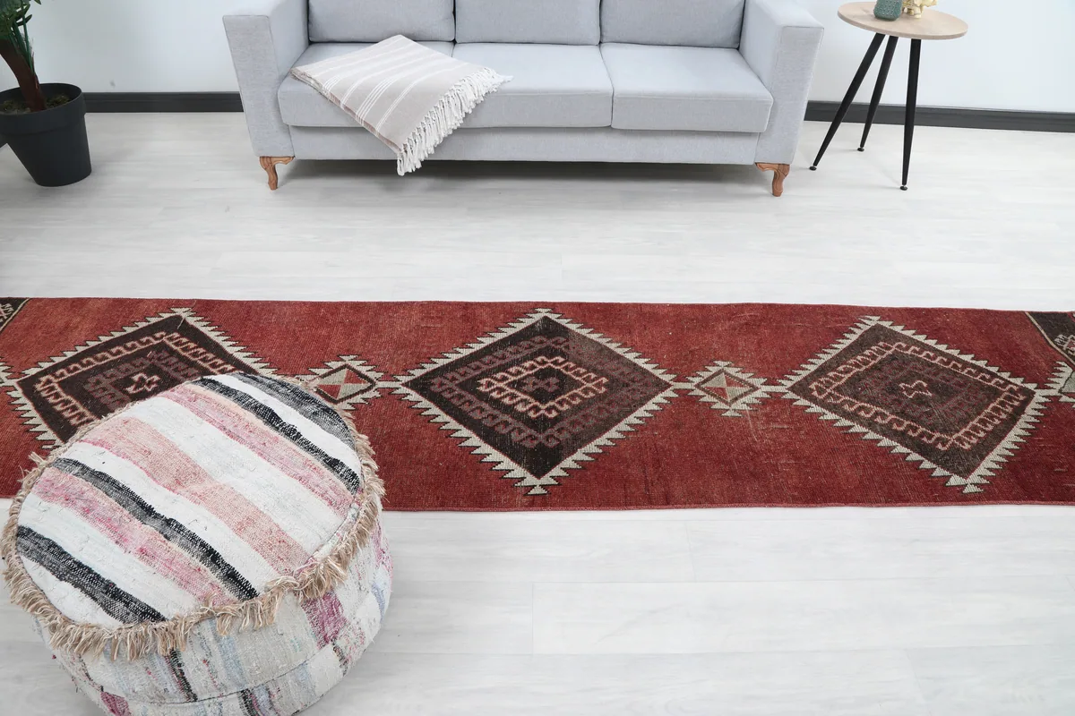 Rustic Red Tribal Diamond Runner laid out in a room, full view with furniture