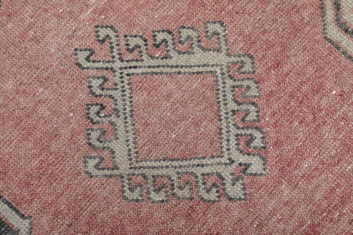 Detailed view of an individual tribal motif within the rose field of the runner.