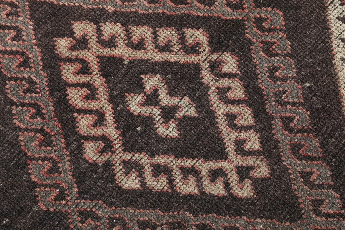 Close-up of the intricate knotting and color variations within a central geometric motif