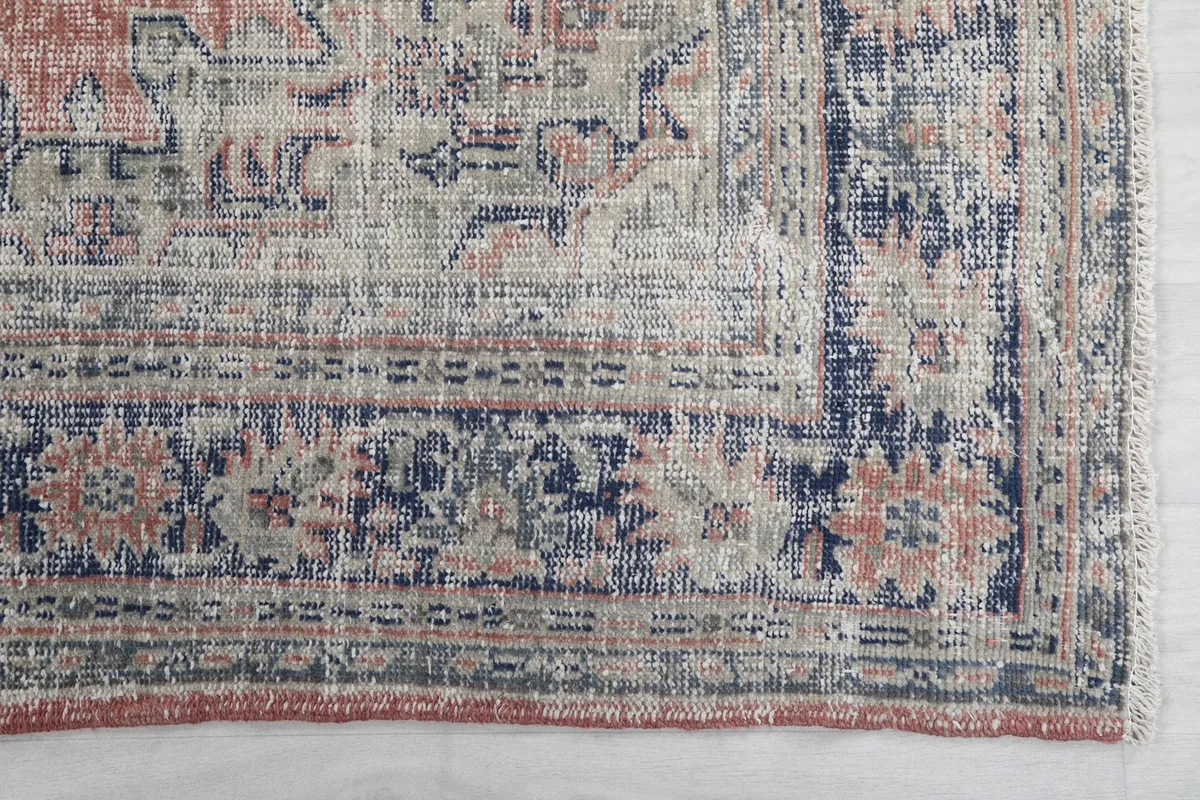 Detail of the navy border design with rust and beige accents on the hand-knotted Anatolian rug.