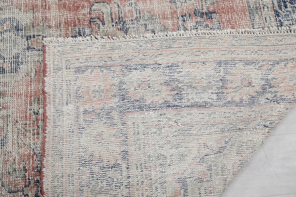 Close-up of the rug's short, natural fringe and a glimpse of the tightly woven back of the rug.