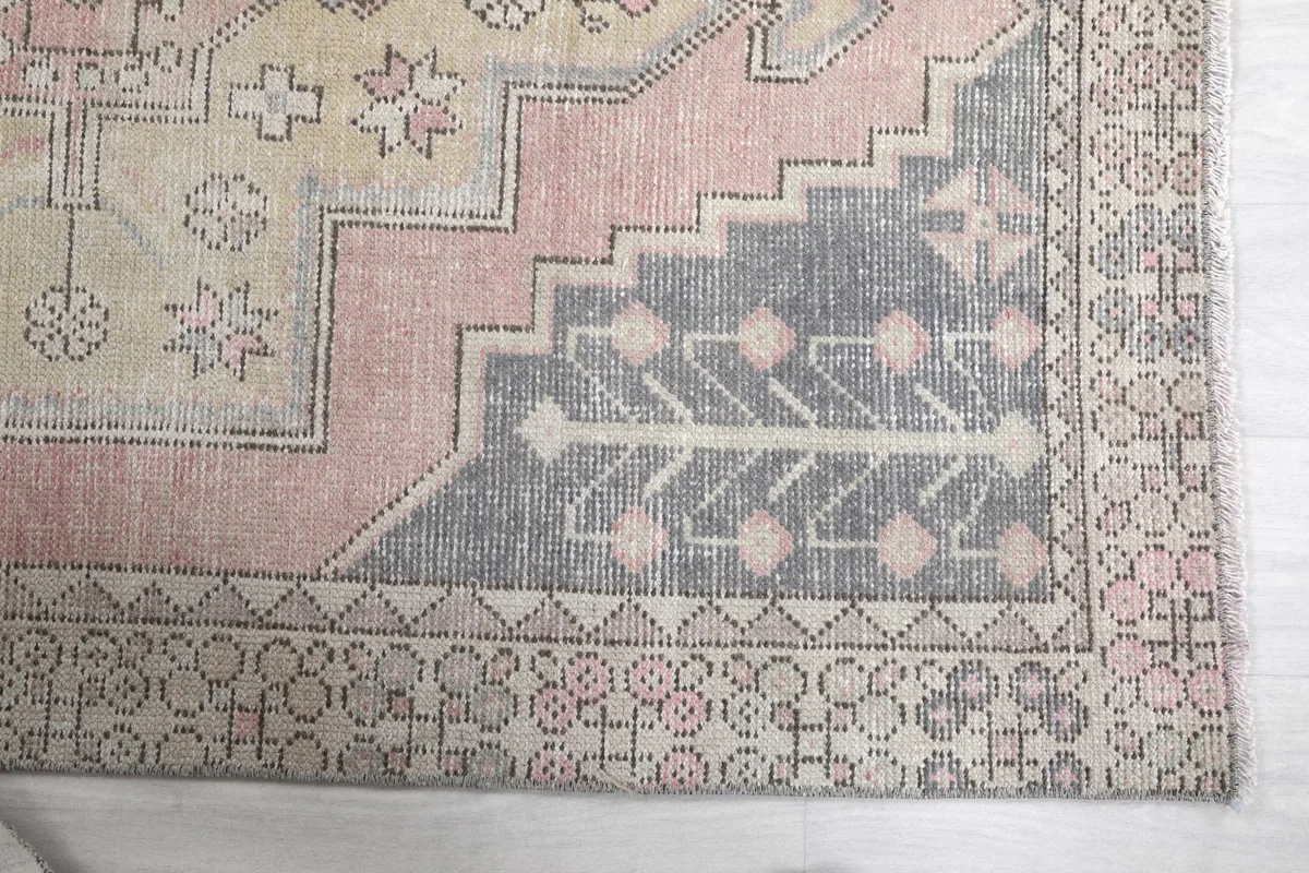 Detailed view of the charcoal border and corner motifs of the hand-knotted rug