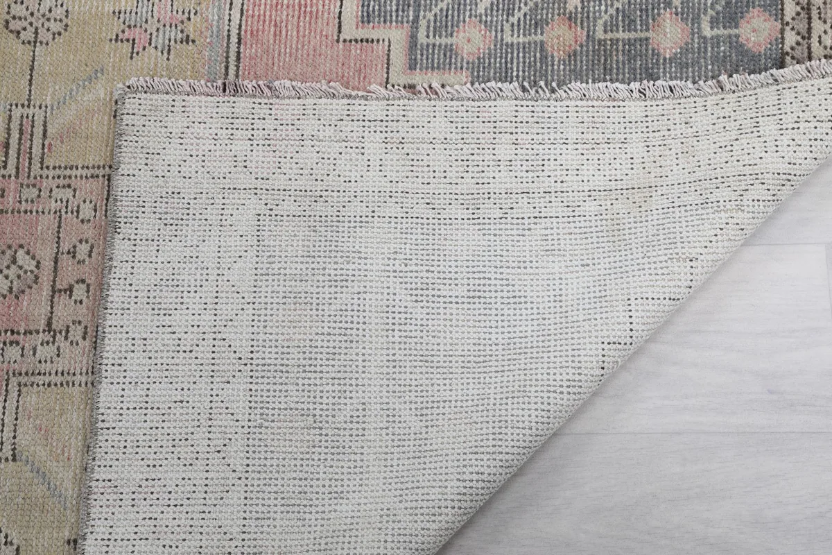 Close-up of the rug's reverse side, showing the knotting and foundation texture
