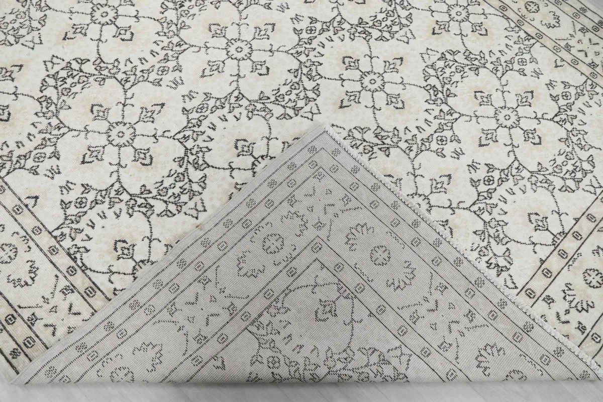 Folded corner of the rug revealing the cotton foundation and the reverse side of the hand-knotted wool