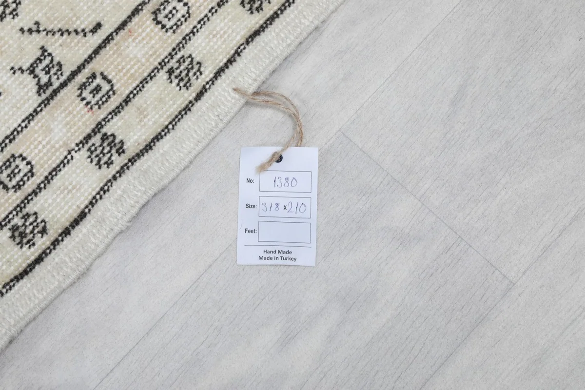 Detail of the rug's edge and a product tag indicating it is hand-made in Turkey