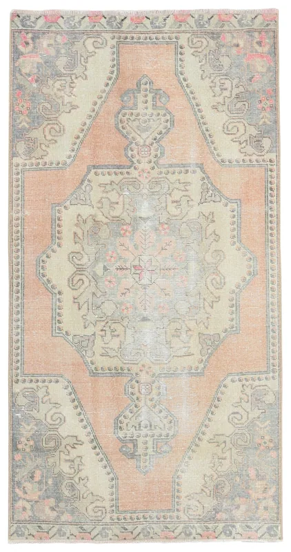 Top view of a vintage Anatolian rug with a rose field, beige medallion, and gray tribal motifs.
