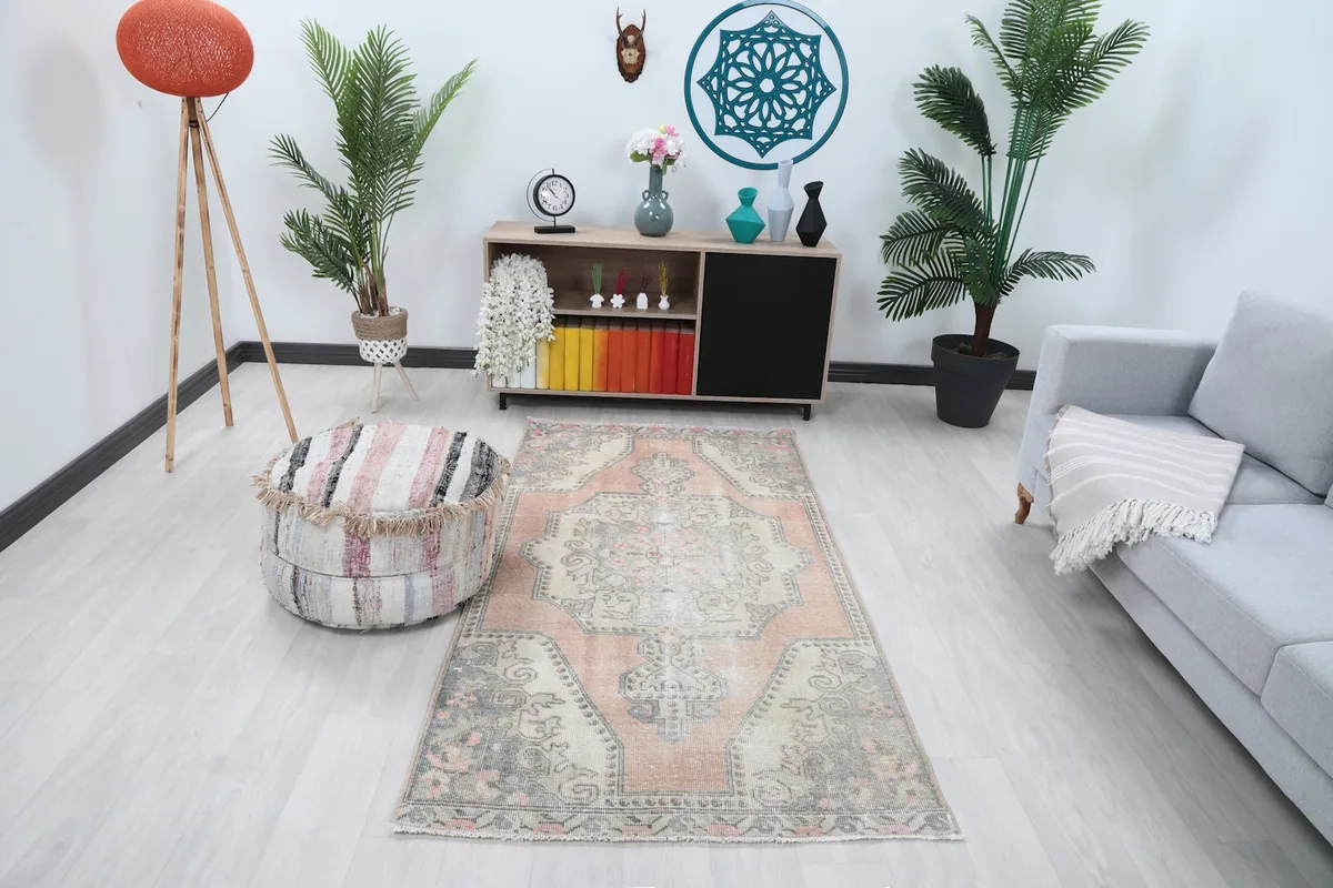 Vintage Anatolian rug displayed in a living room setting with a light gray sofa and modern decor.