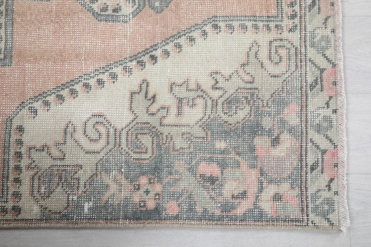 Detailed view of the corner motif, featuring gray and beige tribal patterns with subtle rose accents.