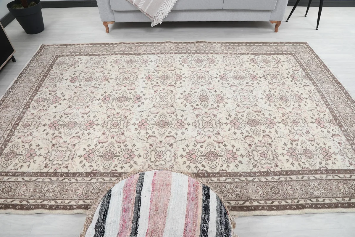 Full front view of the large rug in a room, centered with an ottoman, displaying its overall design.
