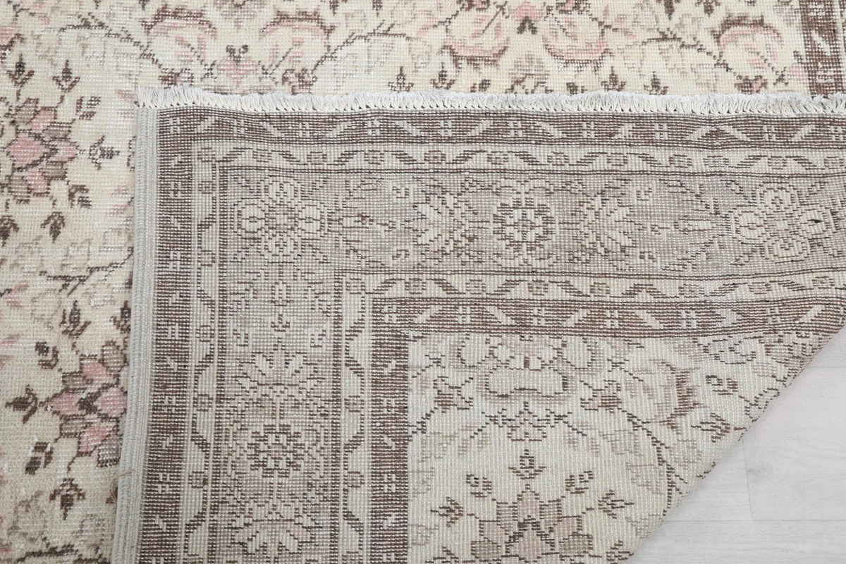 Detailed view of the rug's back, showing the construction and fringe at the edge.
