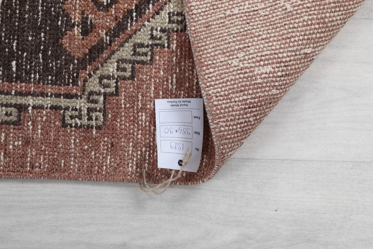 Close-up of the rug's tag with size information, against the wool pile and cotton foundation.
