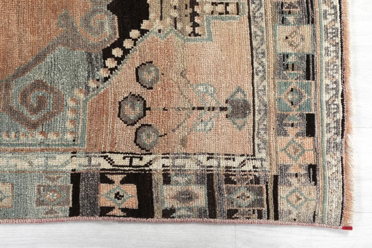 Detailed view of the rug's corner, showcasing the intricate tribal patterns and border design.