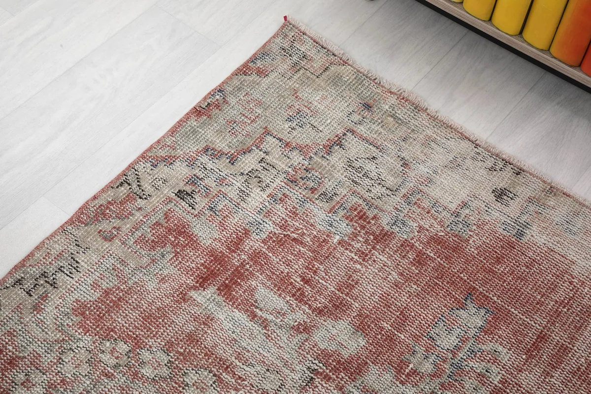 Close-up of the rug's border area, revealing the subtle patterns and distressed finish