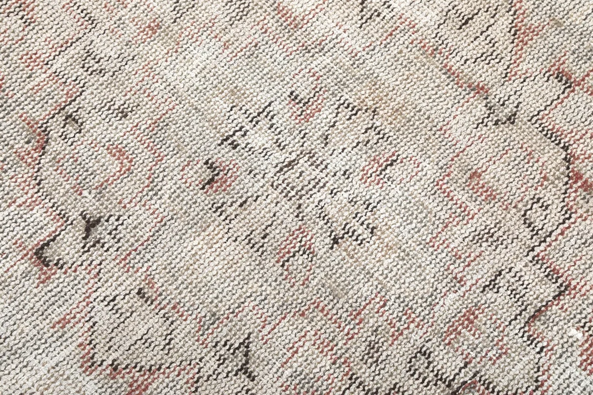 Texture shot of the low wool pile, showing the hand-knotted weave and color variations