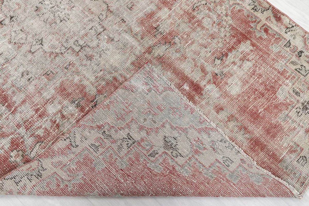 View of the rug's underside and top, showing the cotton foundation and hand-knotted back