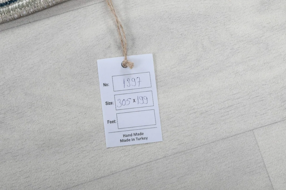Tag indicating the rug's handmade origin and dimensions