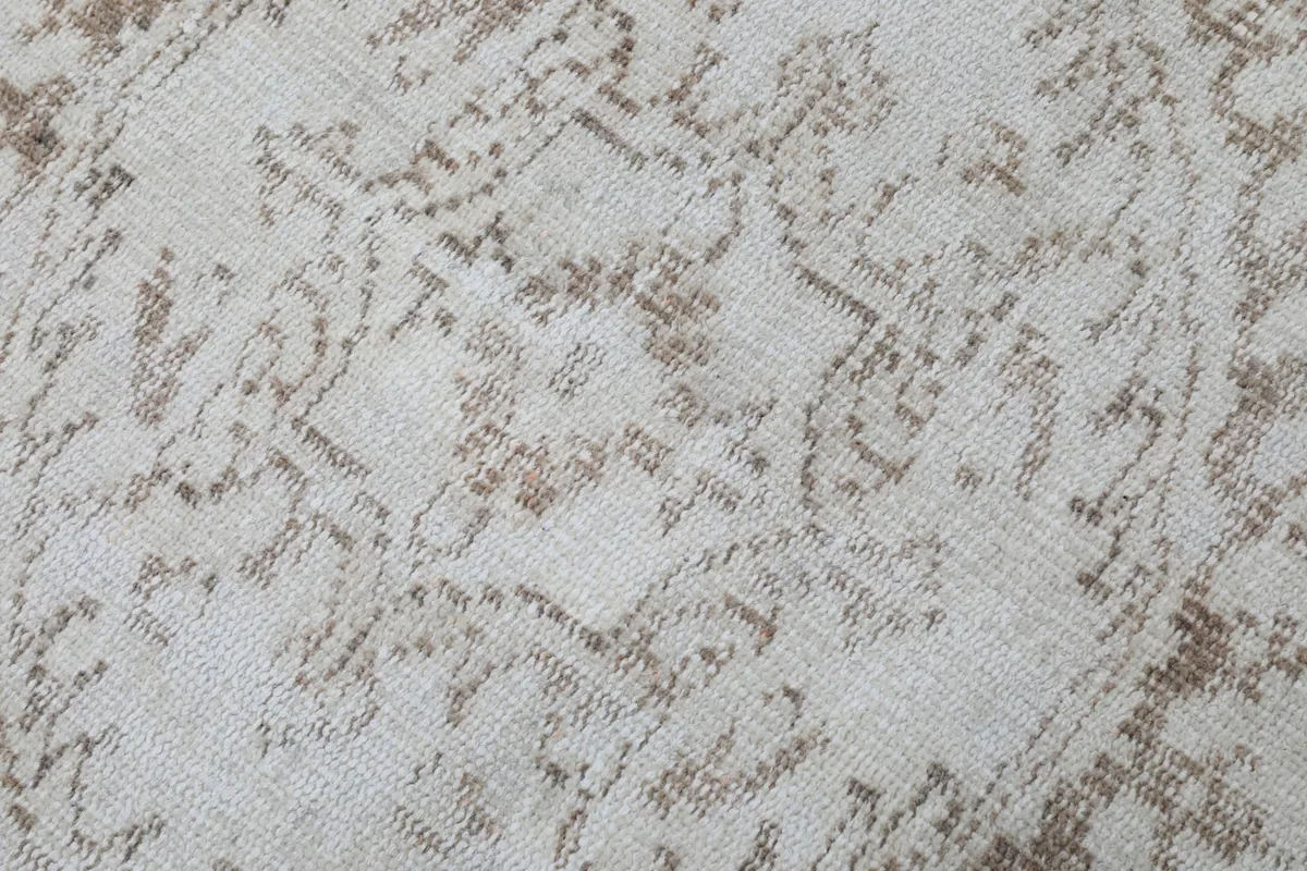 Close-up of the low pile texture and the intricate hand-knotted details of the wool surface
