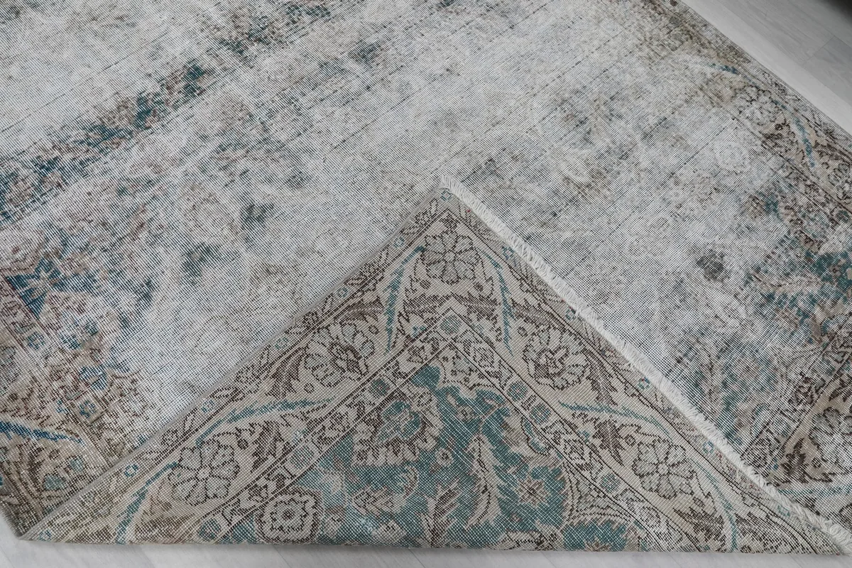 Folded corner of the rug revealing the reverse side with visible hand-knotting and cotton foundation