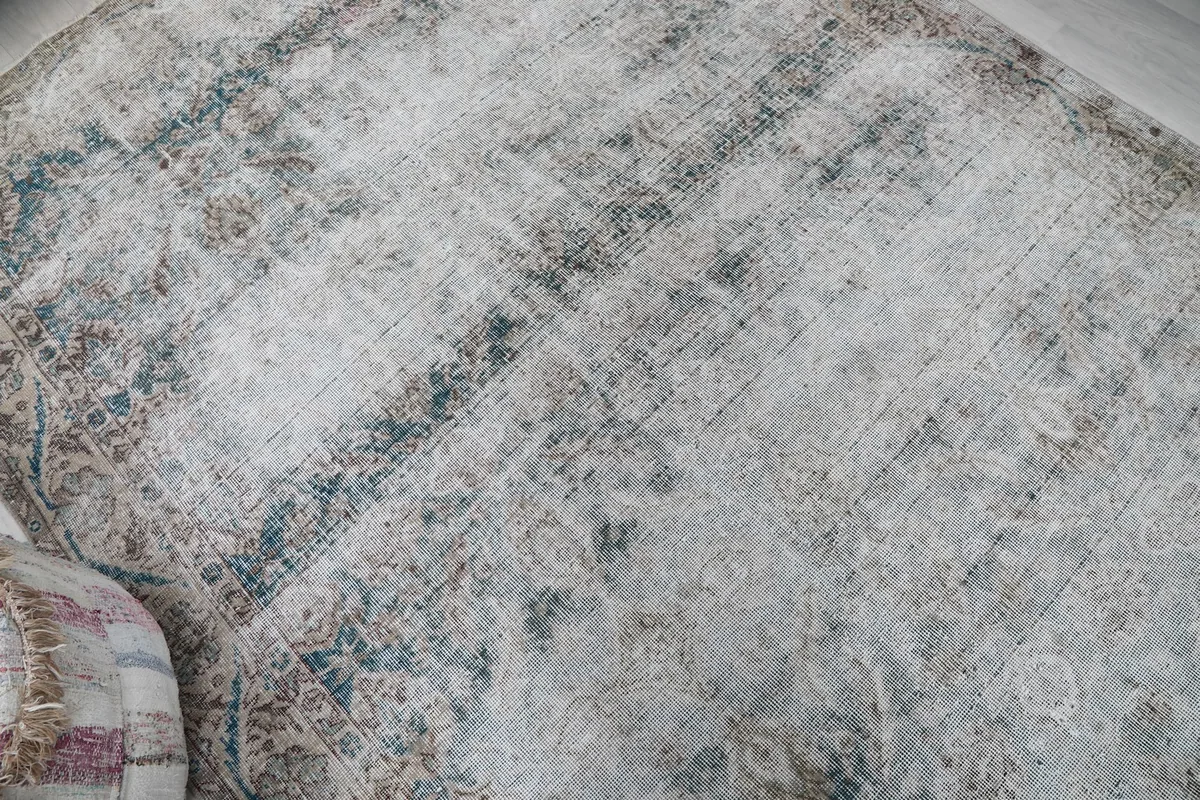 Overhead view highlighting the distressed texture and color variations of the rug