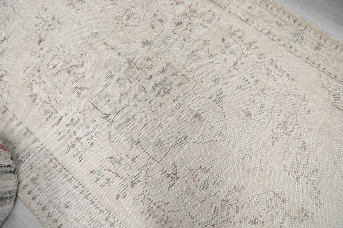 Detailed view of the central floral medallion motif and surrounding faded patterns.