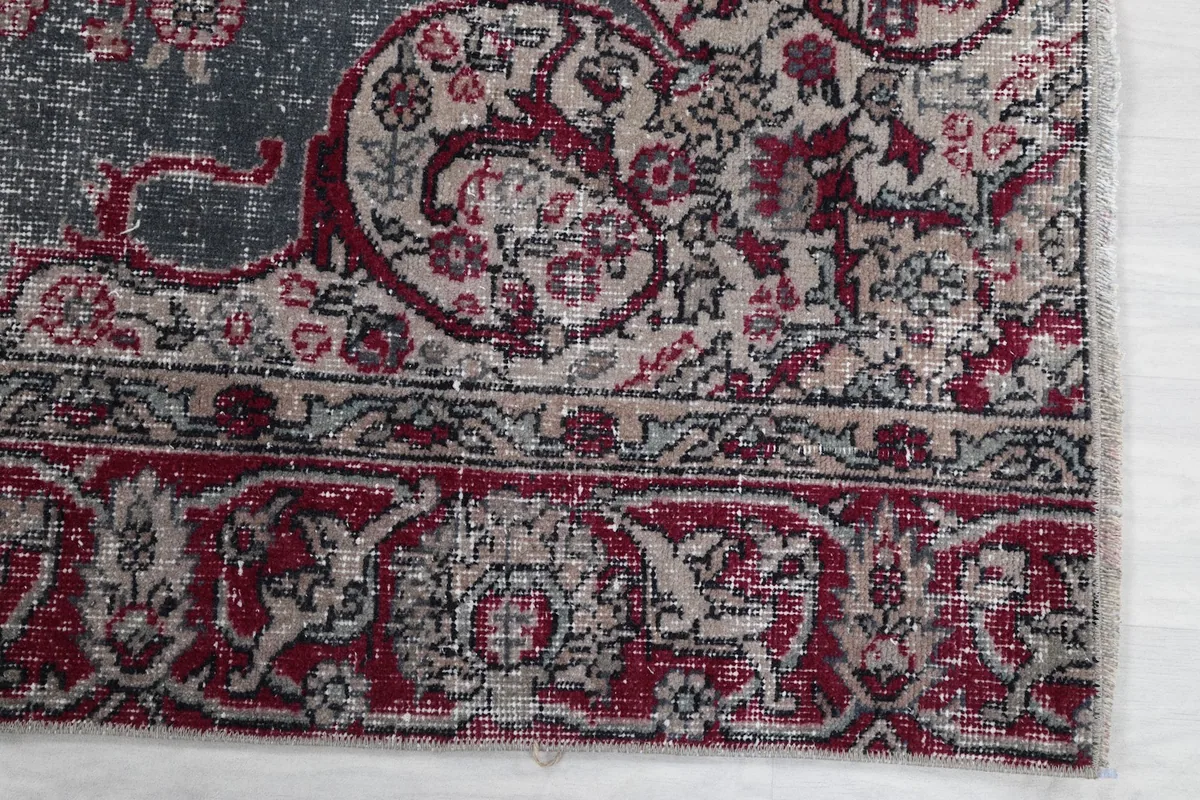Detail view of the intricate red and beige border design on the vintage rug.