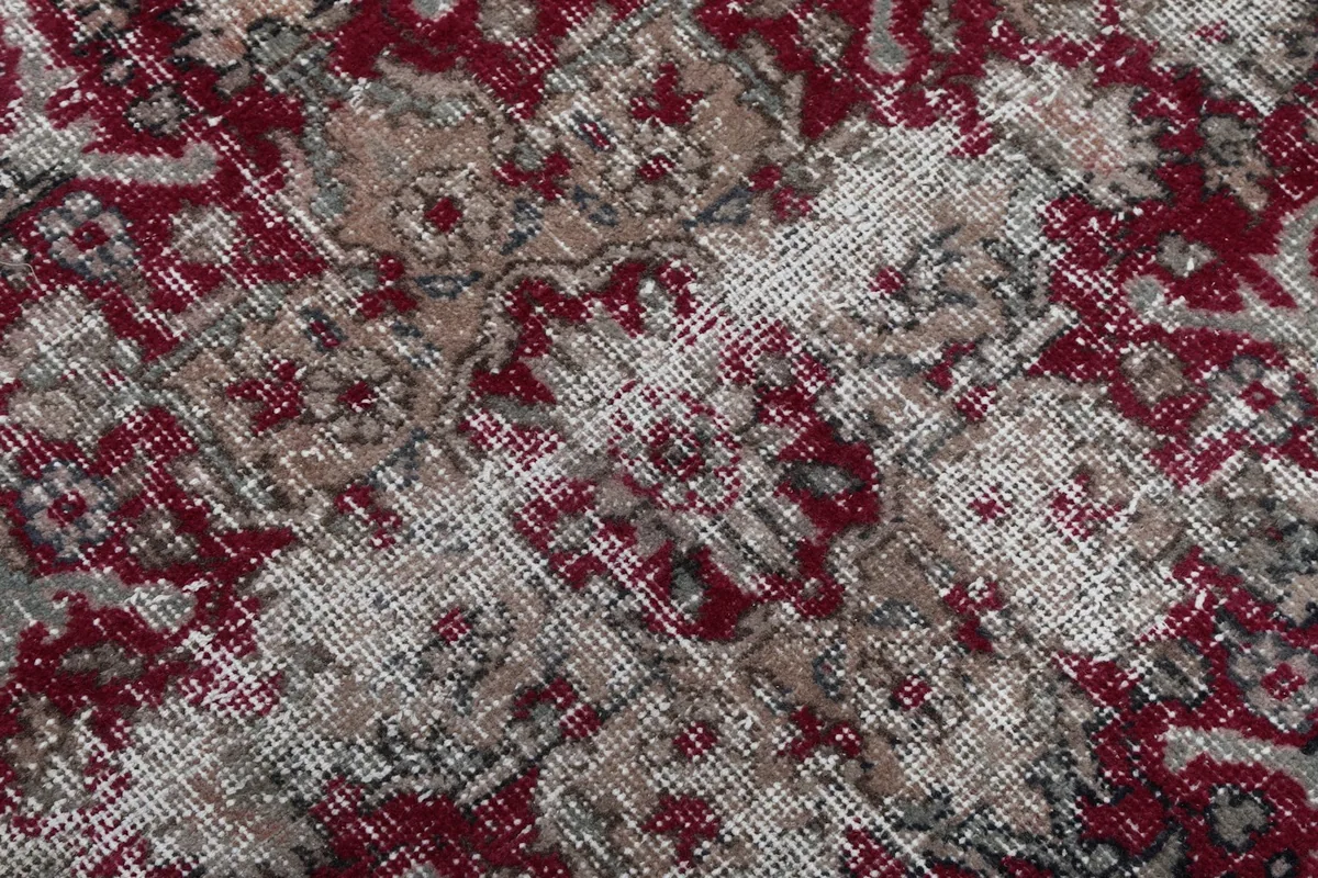 Close-up of the low wool pile, showing texture and areas of natural wear.