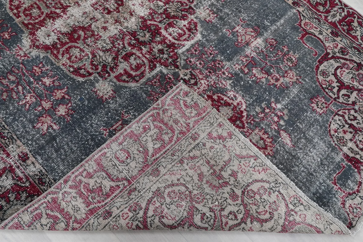 Folded corner revealing the hand-knotted cotton foundation and reverse side of the rug.