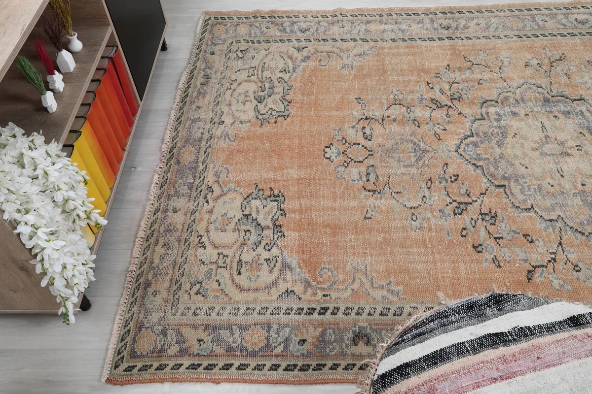 Angle view of the rug's surface, highlighting the faded pile and design elements
