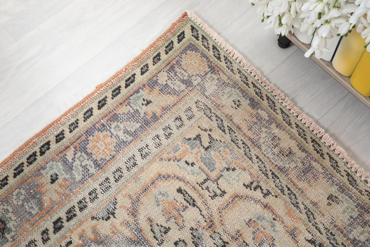 Corner detail of the rug's border, showcasing the hand-knotted texture and fringe