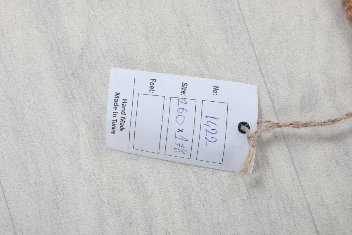 Product tag showing the rug's dimensions in centimeters and origin as Made in Turkey