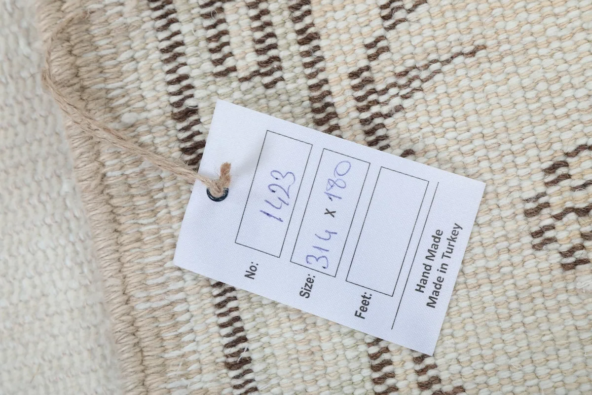 Close-up of the rug's cotton foundation and hand-knotted wool backing with tag