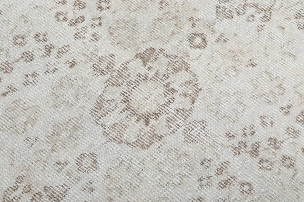 Close-up of a specific floral motif within the rug, showing the wool pile and knotting