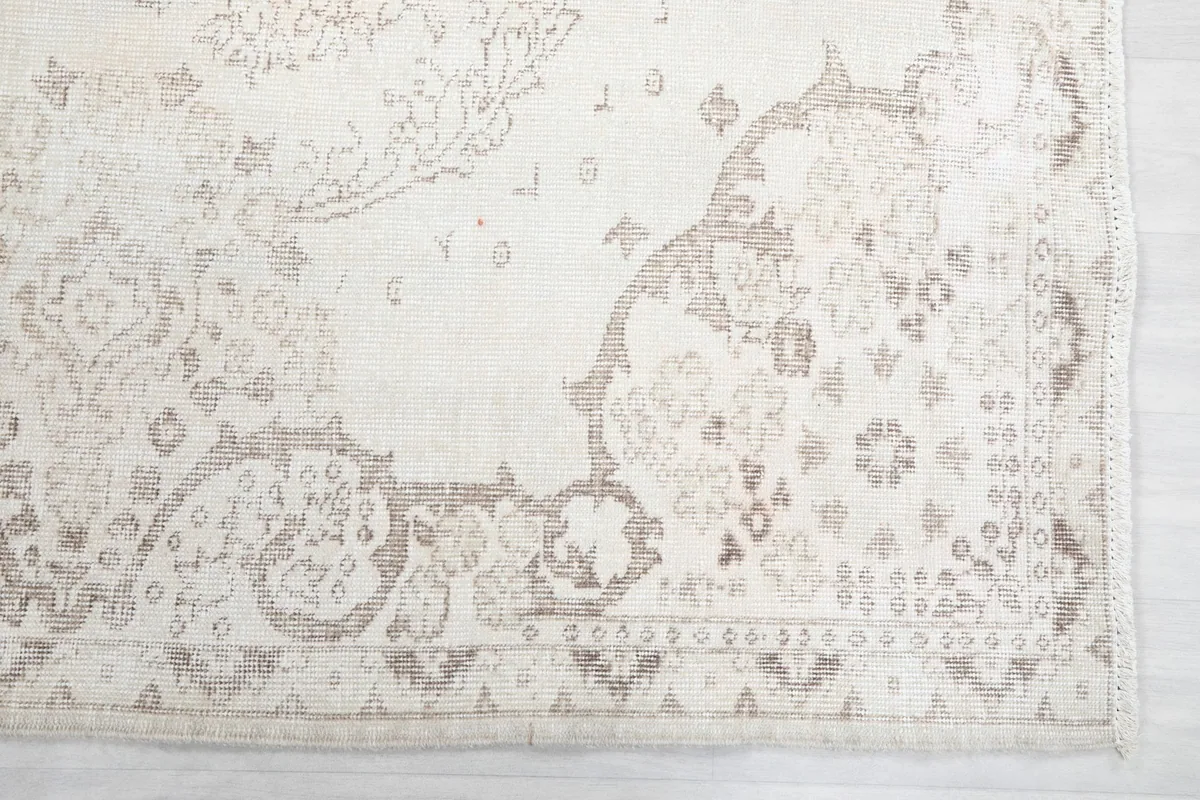 Detail of the border design, highlighting the soft beige tones and traditional patterns