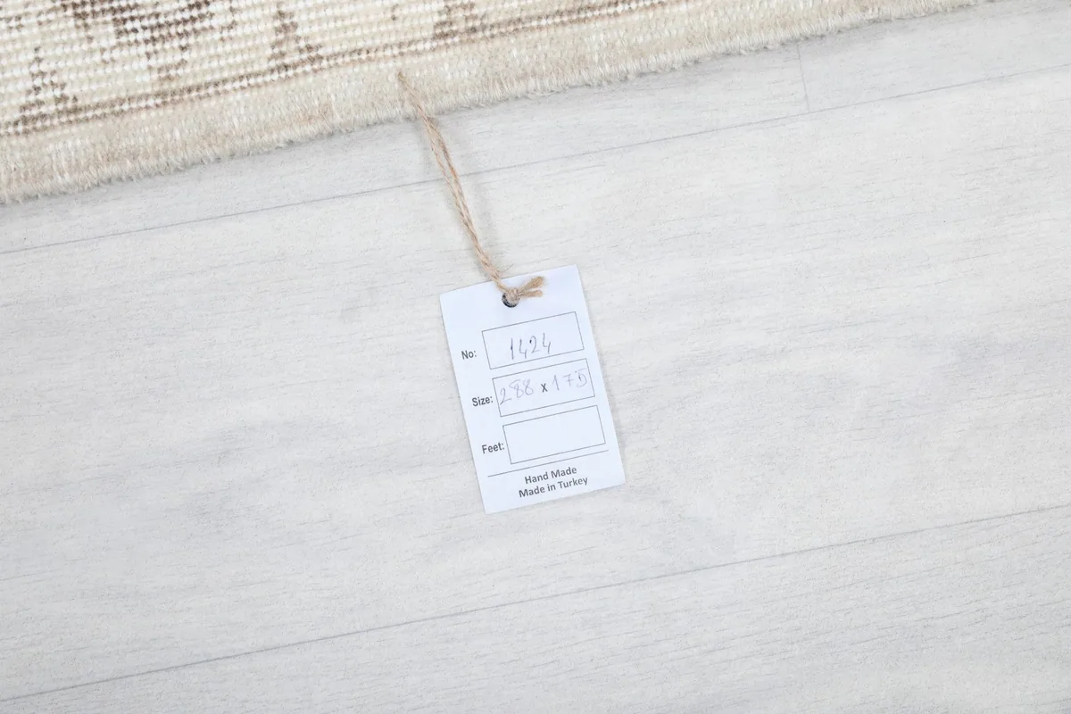 Product tag attached to the rug, indicating its origin as hand-knotted in Turkey