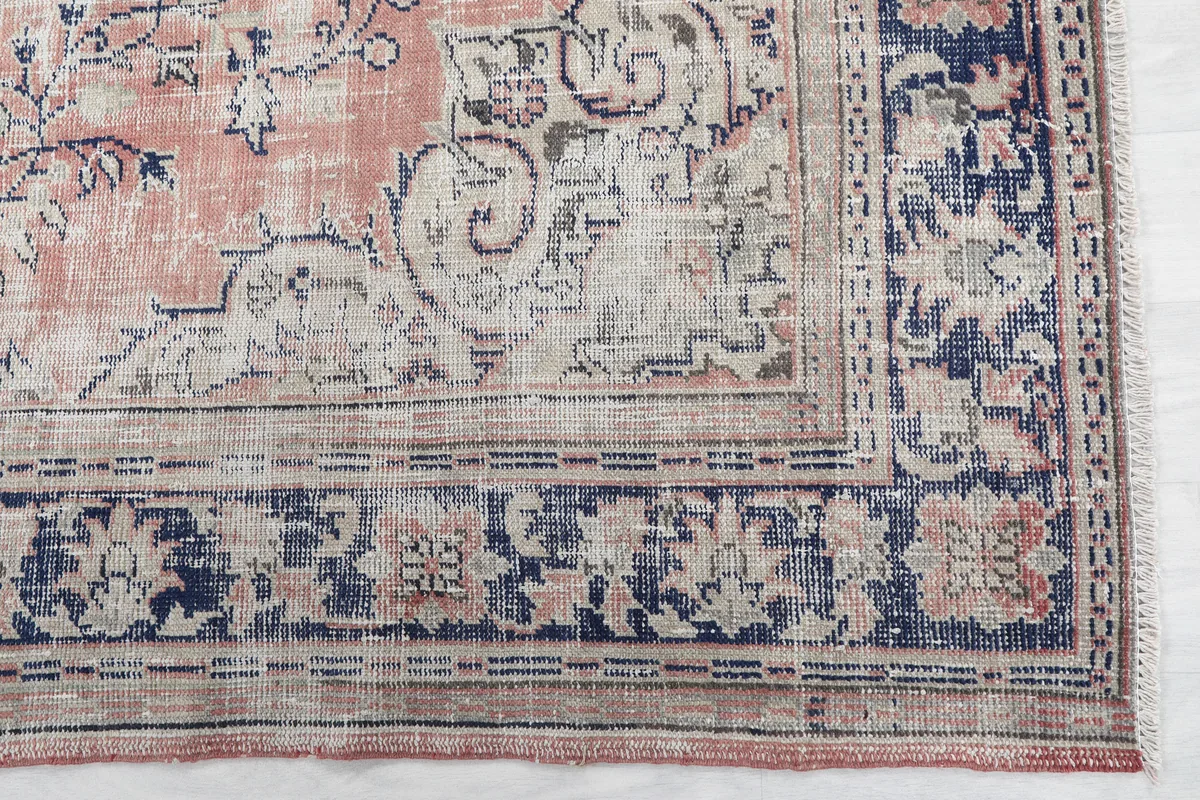 Close-up of the Faded Rose Medallion Vintage Rug's border, showing navy and beige floral details.