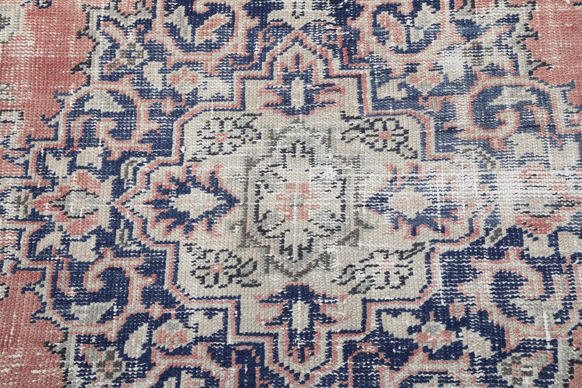 Very close detail of the central medallion on the Faded Rose Medallion Vintage Rug, showing patterns and colors.