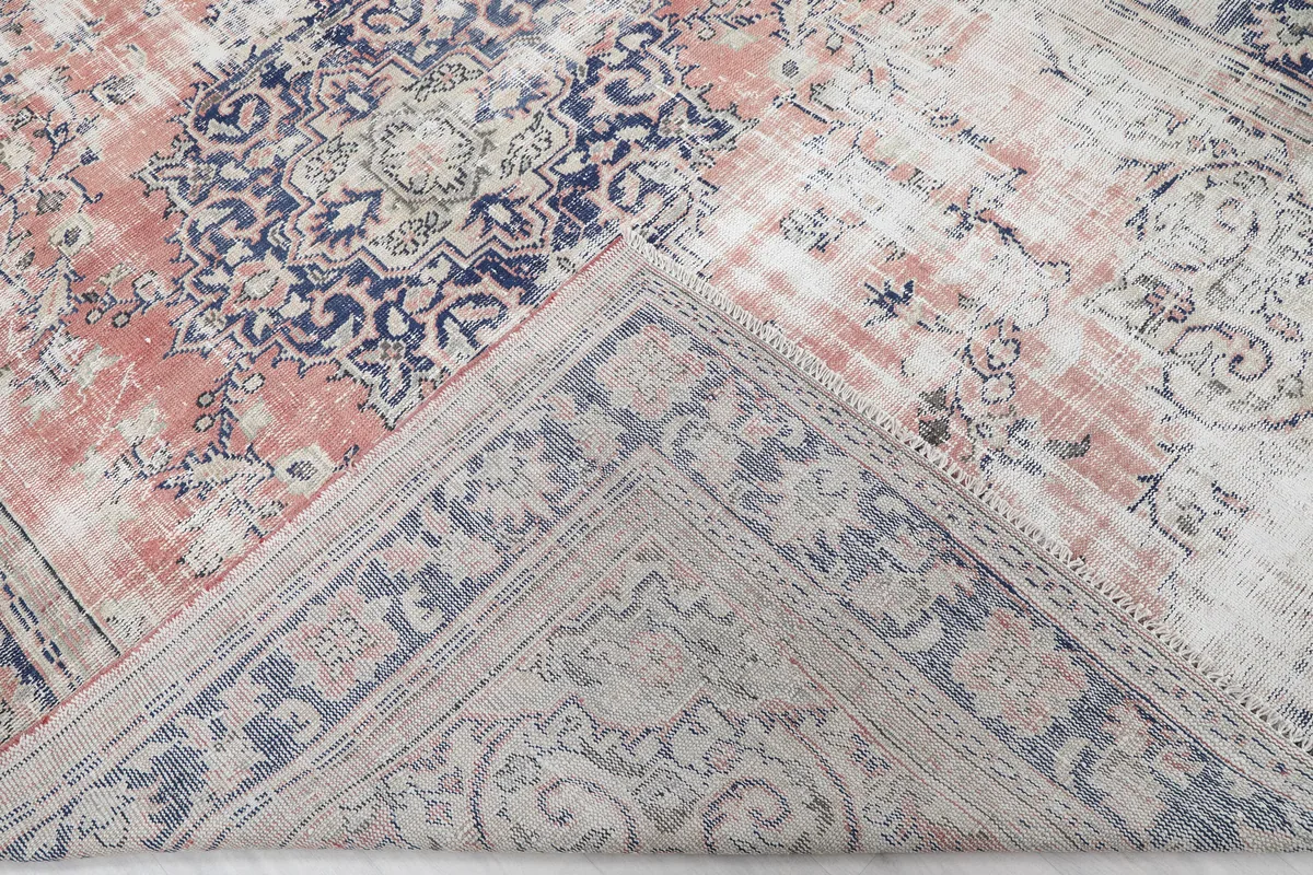 Faded Rose Medallion Vintage Rug partially folded to show the back of the rug and foundation.